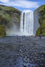 Tourists at the beautiful Skogafoss waterfall in the golden circle of the south of Iceland