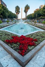 Water fountain and flowers next to the palm trees in the Belen street of the Rambla de Almeria