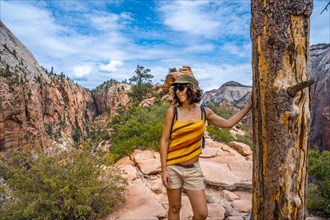 A young woman on top of the trekking of the Angels Landing Trail in Zion National Park