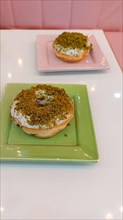 Two matcha flavored donuts in a cute pastel color themed cozy cafe