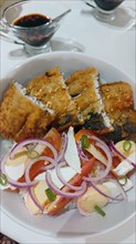 Authentic traditional Filipino breakfast of fried bangus or milkfish with tomato and salted duck egg salad from Philippines