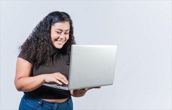 Smiling latin people looking offer promo on laptop isolated. Surprised girl looking at an promotion on laptop screen isolated. Amazed latin woman using laptop