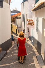 A tourist walking in summer in the town of Paul do Mar in the east of Madeira. Portugal