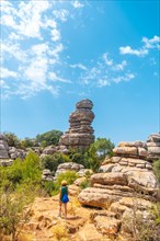 A young woman trekking in the Torcal de Antequera on the green and yellow trail enjoying the summer