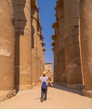 A young tourist wearing a hat visiting the Egyptian Temple of Luxor. Egypt