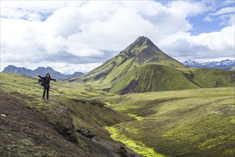 A young woman on a green mountain and a beautiful river of moss on the 54 km trek from Landmannalaugar