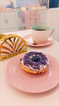 Ube or purple yam flavored donut in a cute pink pastel color themed cafe