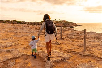 A mother with her son at sunset in Cala Comte beach on the island of Ibiza. Balearic