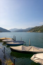 Port with Boats in Brusino Arsizio on the Waterfront in a Sunny Summer Day on Lake Lugano and Mountain View over Morcote