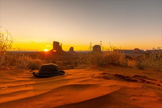A green hat on the red sand at dawn Monument Valley