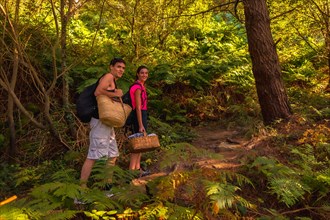 A young Caucasian couple walking along the mountain path towards a romantic summer picnic