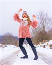 Blonde girl posing in a pink fur jacket