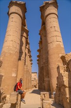 A young tourist next to the precious columns with Egyptian drawings in the Temple of Luxor