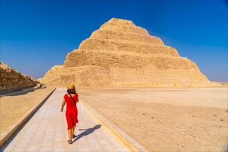A young tourist in a red dress at the Stepped Pyramid of Djoser