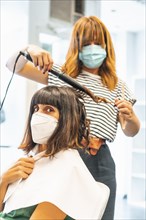 Hairdresser with mask and client