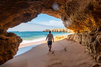 A man in the beach cave at Praia da Coelha