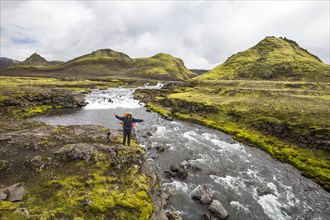 A young man on a large river from the 54 km trek from Landmannalaugar