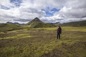 A young girl on a green mountain on the 54 km trek from Landmannalaugar