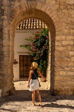 A tourist woman at the old gate of the wall of Vejer de la Frontera