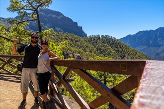 A tourist couple at the Mirador de los Roques on the La Cumbrecita mountain on the island of La Palma next to the Caldera de Taburiente