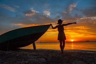 A young woman in a boat at Roatan Sunset from West End. Honduras