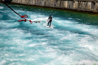 Surfer Surfing on River Aare in City of Thun in a Sunny Summer Day in Bernese Oberland