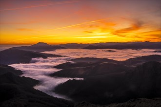 Detail of the beautiful fog between the mountains of the Basque country next to Mount Larrun in the golden hour