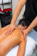 Physiotherapeutic massage to an unrecognizable woman lying on a stretcher on her back with fingers