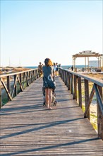 A young mother walking on the walkway of the Bateles beach in Conil de la Frontera
