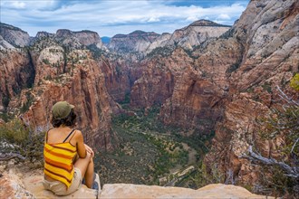A young woman enjoying the views of Zion from the Angels Landing Trail in Zion National Park