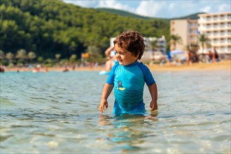 A little boy enjoying the summer on the beaches of Ibiza on holiday at San Vicente beach