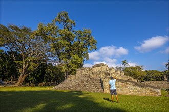 A young man looking at a pyramid in the temples of Copan Ruinas. Honduras
