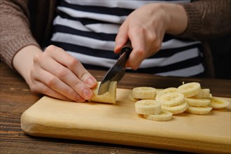 Close up view of hands cutting banana