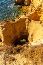 Natural holes in the beautiful coastline in summer at Praia da Coelha