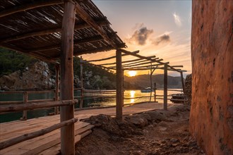 Wooden structure in the beach houses at sunset in Benirras in Ibiza. vacation concept