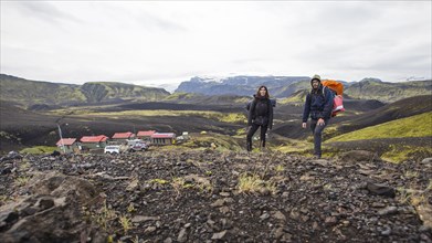 A couple with backpacks leaving the shelter of the 54 km trek from Landmannalaugar