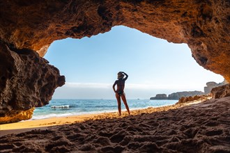 A woman on vacation at the beach cave in the Algarve