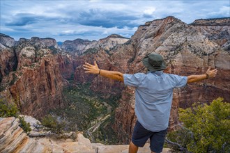 A man celebrating the trekking of Angels Landing Trail in Zion National Park