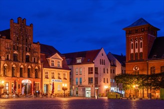 Architecture on the historic market square with Gothic gabled house and old post office building at blue hour