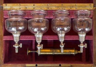 19th century Charriere cupping therapy set showing brass pump and four valved cupping glasses