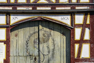 Half-timbered facade and gate painted with imaginative fish in the Swabian Open-Air Museum
