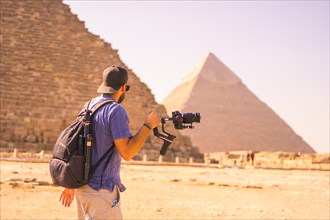 A young photographer at the pyramid of Cheops the largest pyramid. The pyramids of Giza the oldest funerary monument in the world. In the city of Cairo