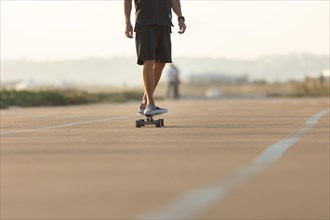 Man skating on the street by the beach. Mid shot