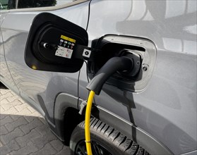 Grey eco-friendly e-car electric powered car vehicle brand Alfa Romeo is charged with e-plug type 2 plug type 2 plug Mennekes standard for Europe