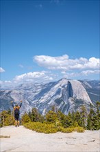 A young man celebrating that he has come walking to Sentinel Dome in Yosemite National Park. United States