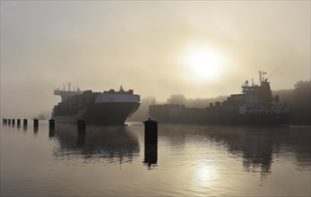 Container ship sailing in fog in Kiel Canal