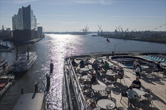 Passengers sitting at tables on the Lido Deck of the cruise ship Vasco da Gama moored at the Ueberseebruecke in the Port of Hamburg