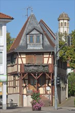 Half-timbered house and church tower of the Gothic collegiate church of the Benedictine monastery