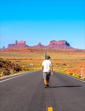 A young man in a white shirt on the road to Monument Valley. Utah