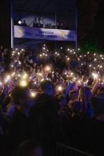 Crowd with mobile phone lights at Live Klostersommer Festival in Historic Monastery